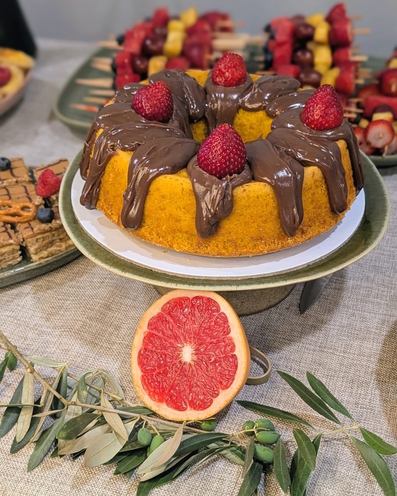 Bolo de cenoura com brigadeiro, toranja e ramo de oliveira sobre linho