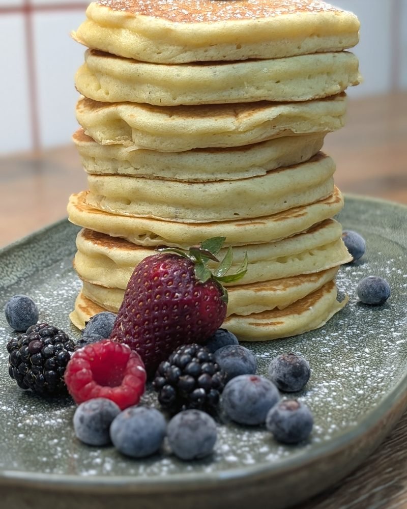 Torre de panquecas com frutos vermelhos e açúcar em pó