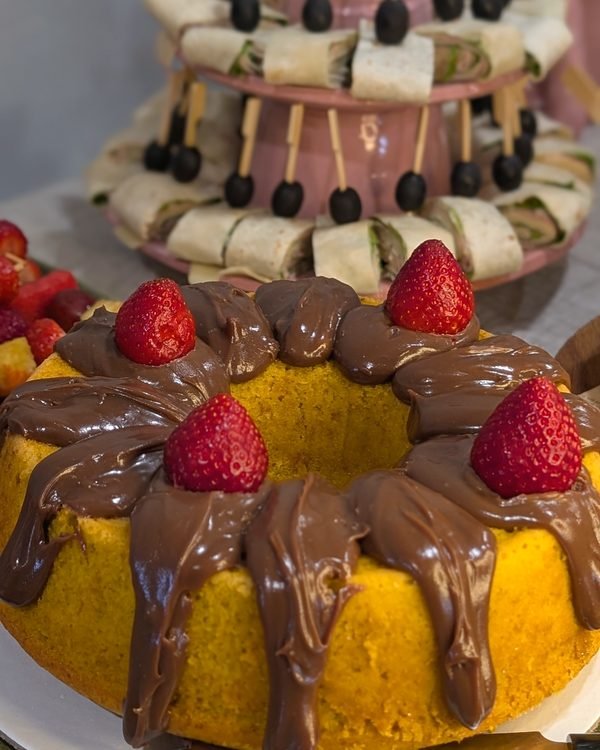 Bolo de cenoura com brigadeiro e morangos numa mesa de festa